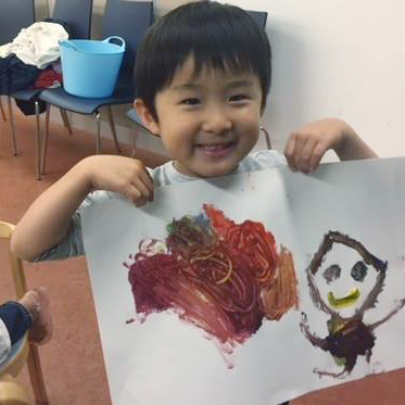 photo of young child holding up finger painting