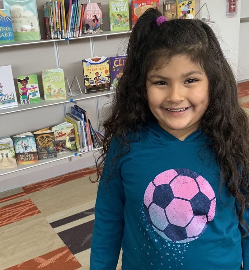 young girl in library sm photo of smiling young girl in library